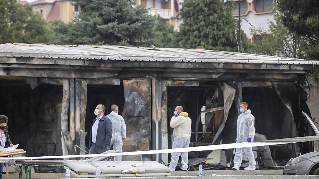 Gerichtsmediziner arbeiten nach einem Brand in einem Behelfskrankenhaus. Nach Angaben des Gesundheitsministeriums in Skopje sind bei dem Brand in Nordmazedonien in der Nacht zum Donnerstag 14 Patienten ums Leben gekommen. Foto: Visar Kryeziu/AP/dpa