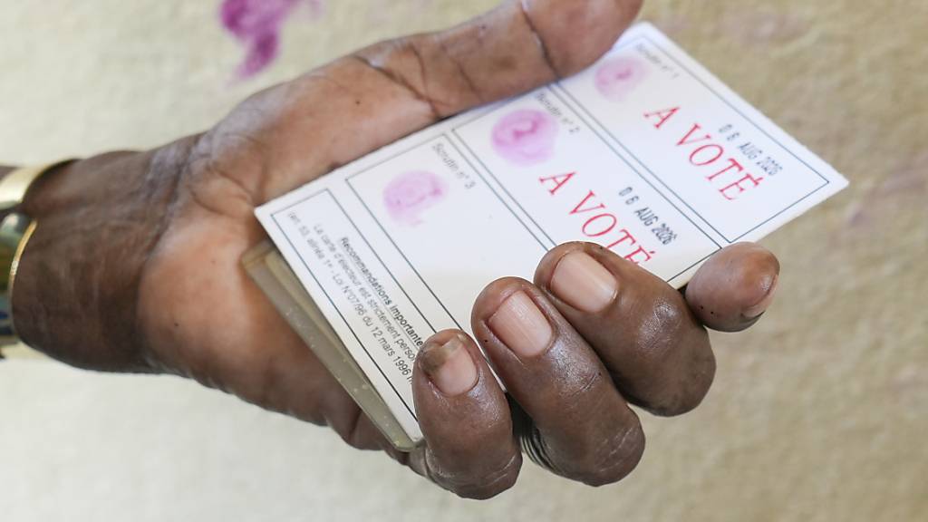 ARCHIV - Ein Wähler zeigt seine gestempelte Wahlkarte beim Verfassungsreferendum im November 2024. Foto: Betines Makosso/AP/dpa/Archivbild
