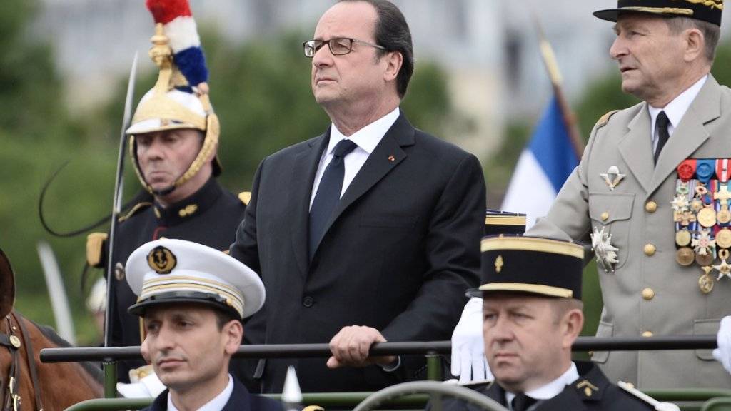 Der französische Präsident François Hollande nimmt zusammen mit General Pierre de Villiers die Militärparade zum Nationalfeiertag ab.