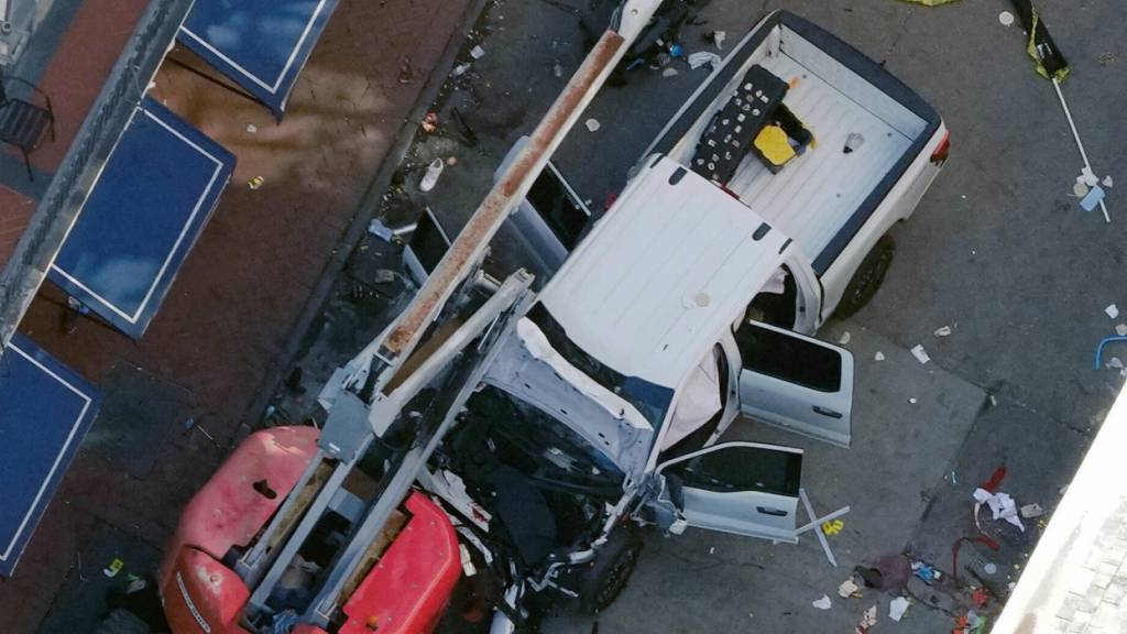 Eine schwarze Flagge mit weißer Schrift liegt zusammengerollt auf dem Boden hinter einem Pick-up-Truck, den ein Mann in eine Menschenmenge auf der Bourbon Street in New Orleans fuhr und dabei mehrere Menschen tötete und verletzte. Foto: Gerald Herbert/AP/dpa