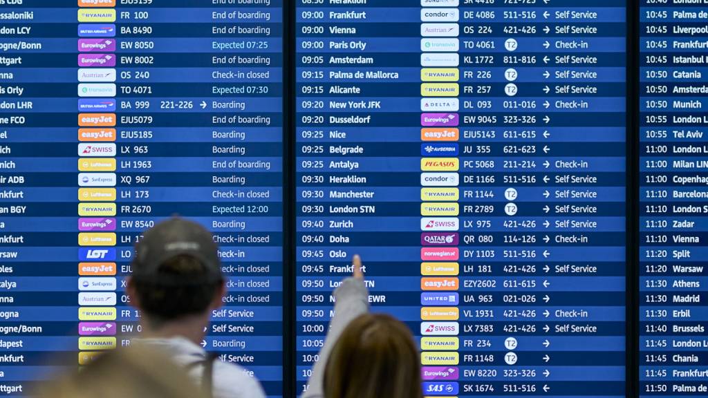 Fluggäste informieren sich an den Abflugtafeln im Terminal 1 des Flughafens Berlin Brandenburg. Nach einem breit angelegten Cyberangriff auf europäische Flughäfen bekommen Passagiere die Auswirkungen zu spüren. Foto: Michael Ukas/dpa