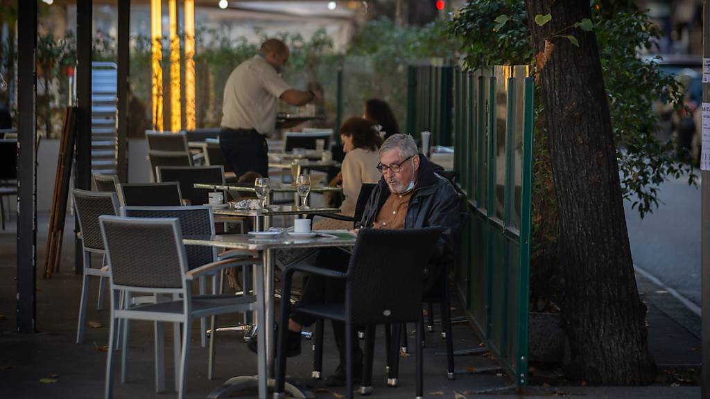 Ein Mann liest auf der Terrasse eines Cafés in Barcelona. Foto: David Zorrakino/EUROPA PRESS/dpa