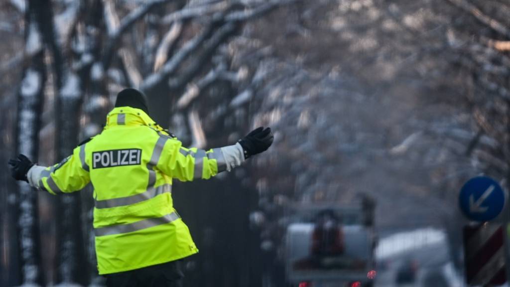 Ein Polizist regelt den Verkehr an einer Kreuzung, an der die Ampel ausgefallen ist. Zehntausende Menschen im Südwesten der Hauptstadt haben keinen Strom. Foto: Britta Pedersen/dpa