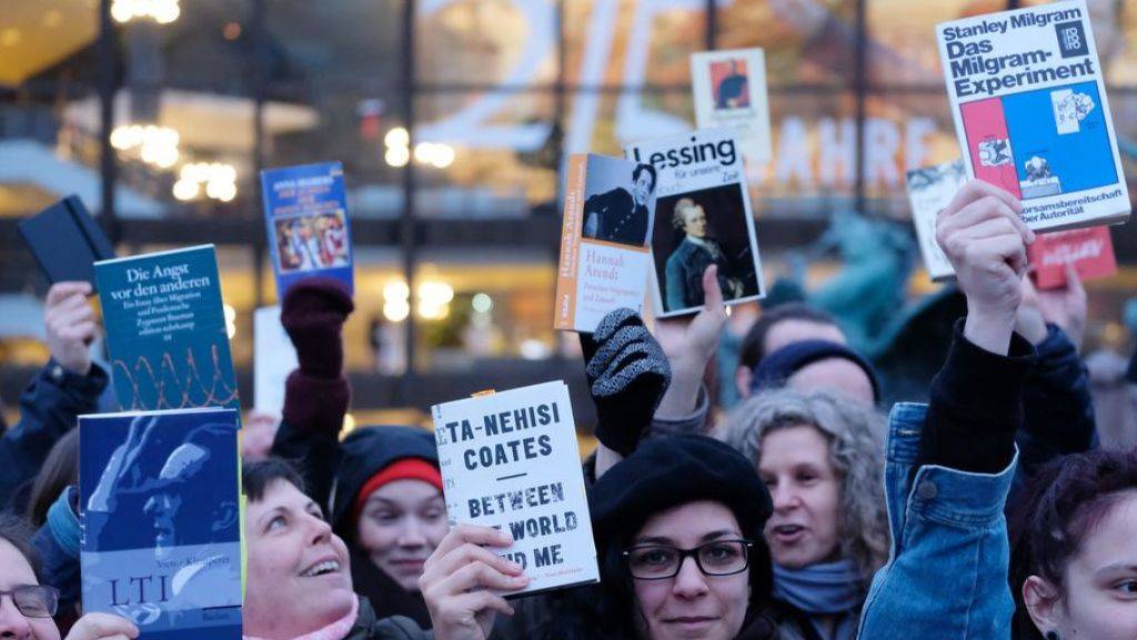 Teilnehmer einer Demonstration halten auf dem Augustusplatz in Leipzig Bücher in die Höhe. Etwa 200 Menschen protestierten gegen die Präsenz rechter Verlage auf der Leipziger Buchmesse.