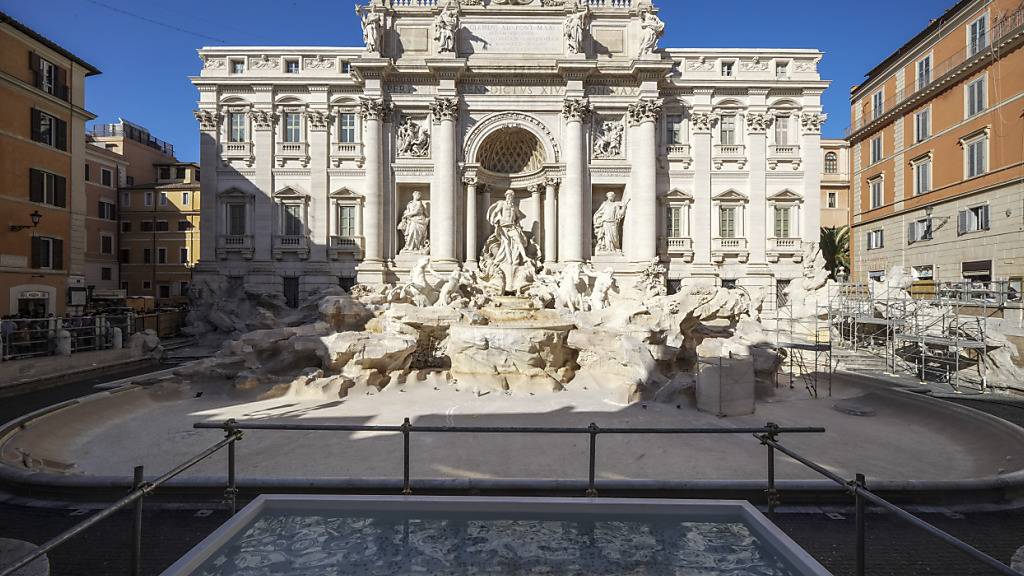 Vor dem Trevi-Brunnen ist ein kleines Becken zu sehen, in das Touristen ihre Münzen werfen können. Der Brunnen wurde geleert, um Wartungsarbeiten durchzuführen, die bis etwa September 2025 dauern werden. Foto: Andrew Medichini/AP/dpa