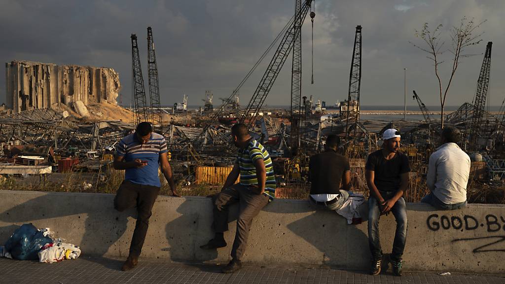 dpatopbilder - Menschen sitzen in der Nähe des Ortes der verheerenden Explosion im Hafen Beiruts. Foto: Felipe Dana/AP/dpa