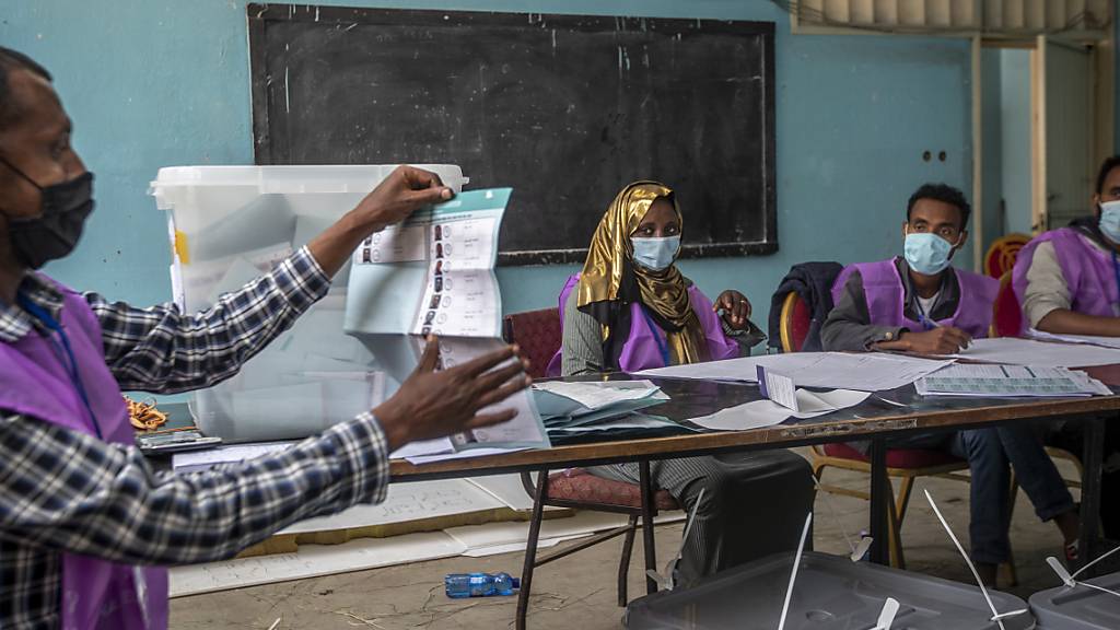 Wahlhelfer zählen Stimmen in einem Wahllokal. Die Parlamentswahl in Äthiopien wird in der Region Sidama um einen zweiten Tag verlängert. Am Wahltag habe es an Stimmzetteln gefehlt, sagte die Wahlkommission am späten Montagabend. Foto: Ben Curtis/AP/dpa