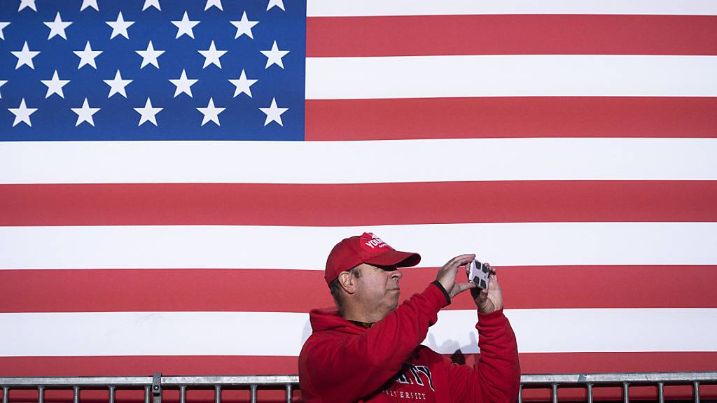 Ein Mann macht Bilder, während er auf die Ankunft des republikanischen Gouverneurskandidaten Glenn Youngkin bei einer Wahlkampfveranstaltung in Leesburg, Virginia, wartet. Foto: Cliff Owen/AP/dpa