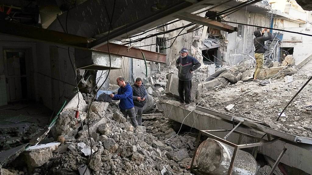 Mitarbeiter inspizieren ein Gebäude des Krankenhauses Al-Ahli, das von der israelischen Armee angegriffen wurde. Foto: Jehad Alshrafi/AP/dpa