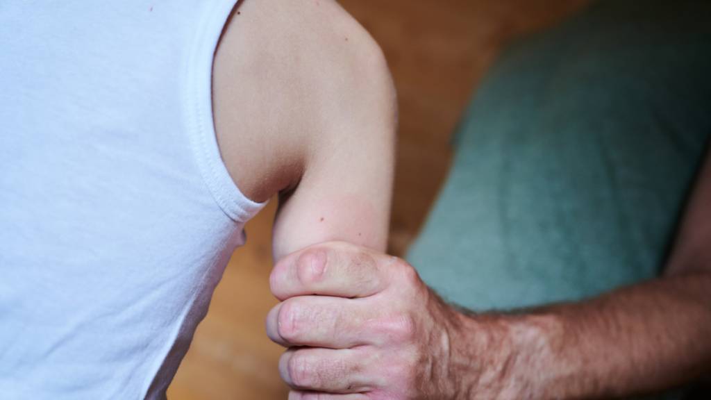 ARCHIV - Ein Mann hält ein Kind fest am Arm (gestellte Szene). Foto: Annette Riedl/dpa