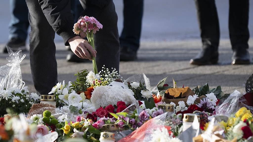 Ein Passant legt Blumen vor dem Eingang der Johanniskirche nieder. Foto: Sebastian Kahnert/dpa