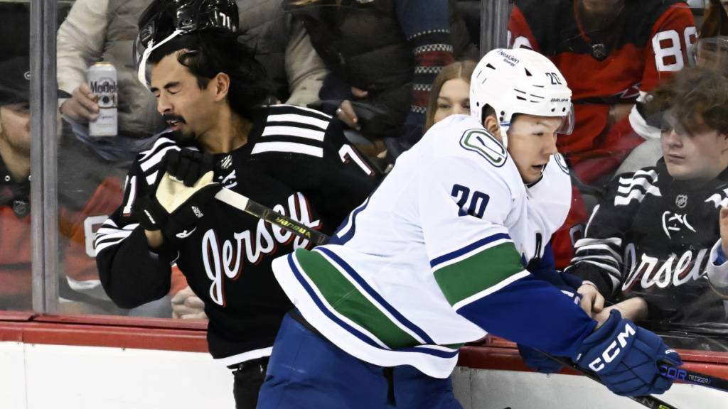 Curtis Lazar (rechts), im Trikot der Vancouver Canucks, checkt den Schweizer Verteidiger Jonas Siegenthaler von den New Jersey Devils