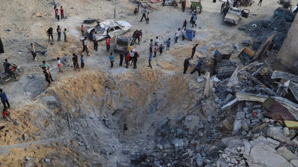 Palästinenser inspizieren die von einem israelischen Bombardement betroffene Stelle in Muwasi, Khan Younis, Gazastreifen. Foto: Mariam Dagga/AP/dpa/Archivbild