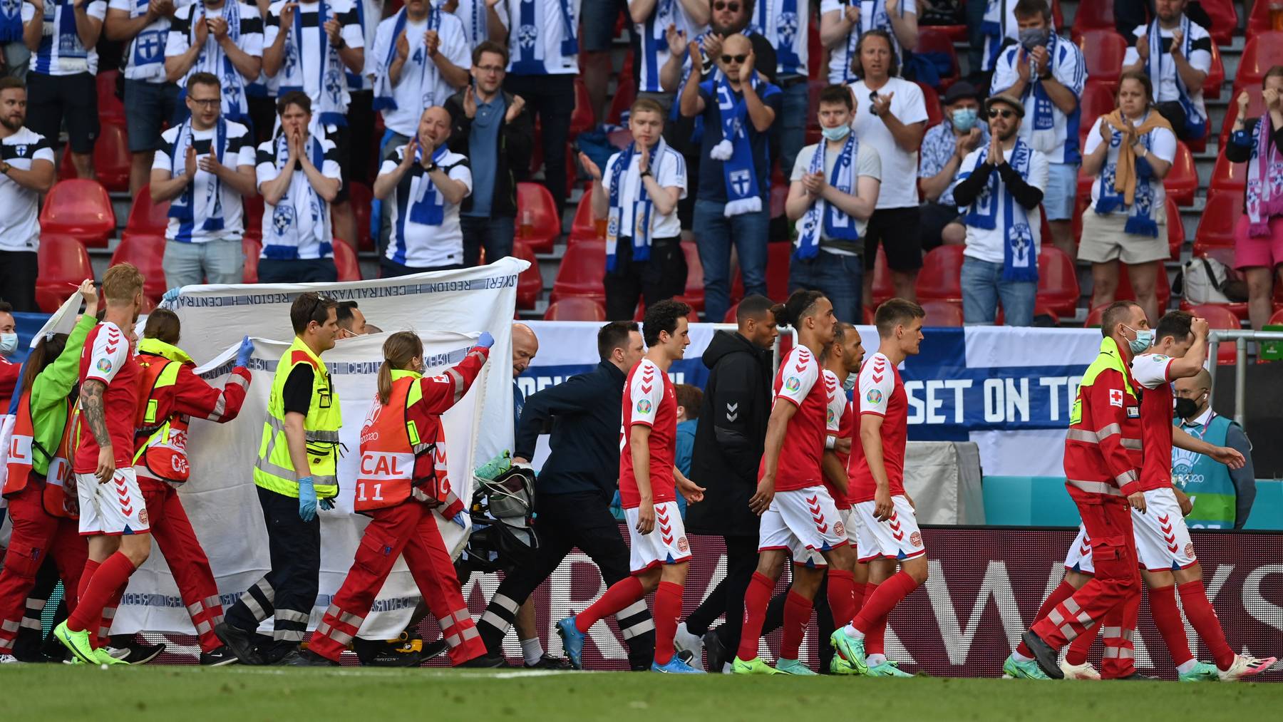 Supporters of Finland react while Christian Eriksen (hidden) of Denmark is carried from the pitch during the UEFA EURO 2020 group B preliminary round soccer match between Denmark and Finland in Copenhagen, Denmark, 12 June 2021. 