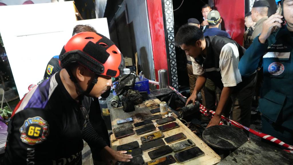 dpatopbilder - Rettungskräfte bergen die Mobiltelefone von den Opfern eines Brandes. Bei einem Feuer in einem Bierlokal in der thailändischen Hauptstadt Bangkok sind nach Medienberichten mehrere Menschen ums Leben gekommen. Foto: Sakchai Lalit/AP/dpa
