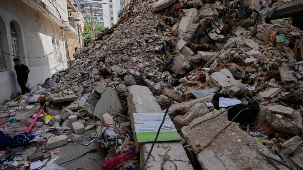 ARCHIV - Ein Junge geht an einem zerstörten Gebäude vorbei, das vor einer Woche bei einem israelischen Luftangriff im Zentrum von Beirut, getroffen wurde. Foto: Hussein Malla/AP/dpa