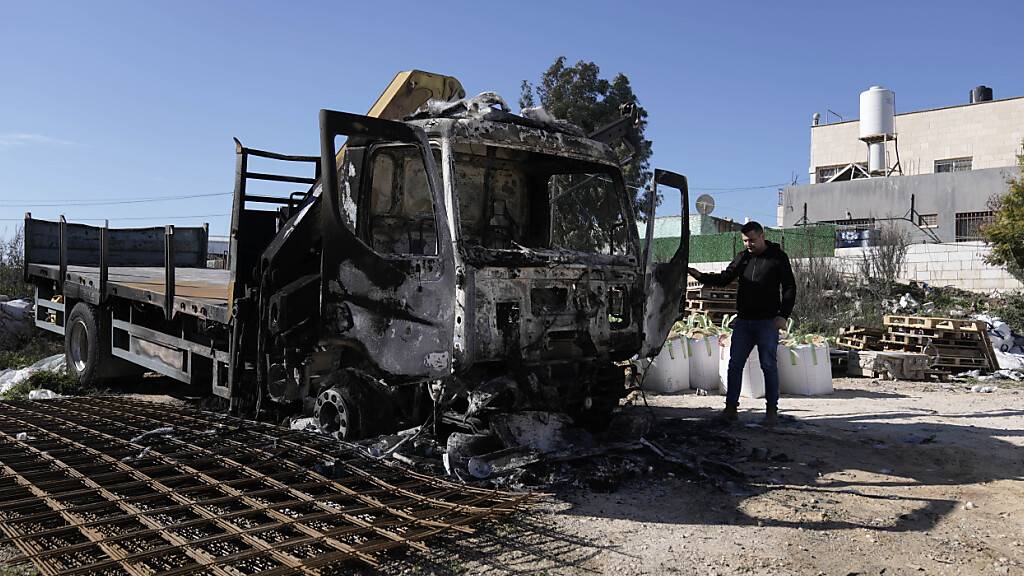 Ein Palästinenser steht neben einem Lastwagen, der bei einem Angriff israelischer Siedler im Westjordanlanddorf Jinsafut in Brand gesetzt wurde. Foto: Majdi Mohammed/AP/dpa