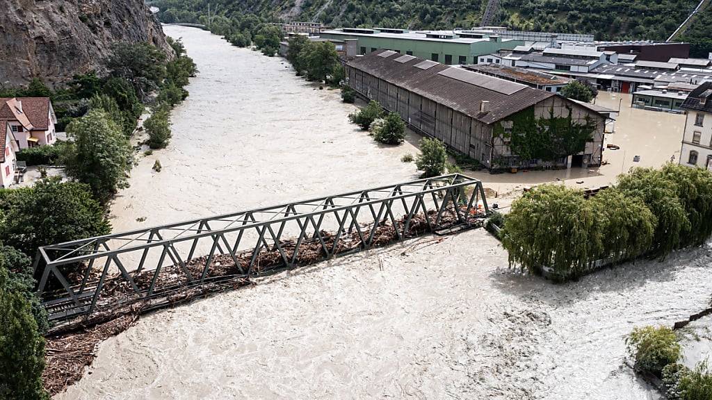 Weil die Rhone Hochwasser führt, wird ein Industriegebiet bei Aigle VD vorsorglich geräumt. Im Bild die hoch gehende Rhone bei Chippis VS.