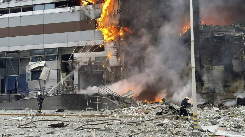 Feuerwehrleute an einem Gebäude, das nach einem russischen Angriff in Kiew beschädigt wurde.
