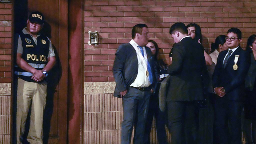 ARCHIV - Polizisten  und Staatsanwälte  vor dem Haus der peruanischen Präsidentin Boluarte während einer von der Generalstaatsanwaltschaft angeordneten Hausdurchsuchung, bei der Rolex-Uhren im Rahmen einer Voruntersuchung wegen mutmaßlicher illegaler Bereicherung beschlagnahmt werden. Foto: Martin Mejia/AP/dpa