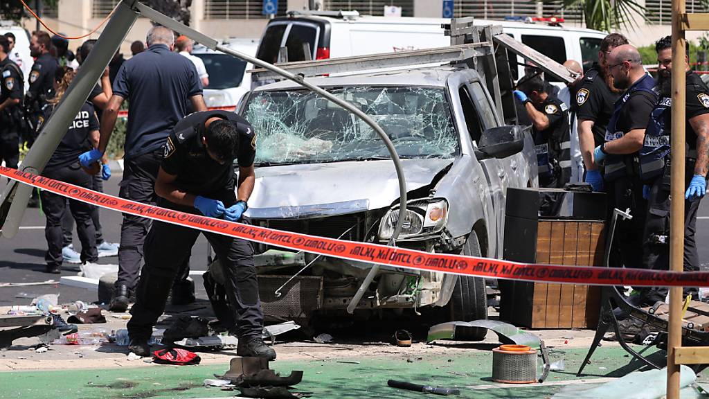 Israelische Sicherheits- und Rettungskräfte inspizieren den Ort eines Anschlags mit einem Auto in Tel Aviv. Foto: Ilia Yefimovich/dpa
