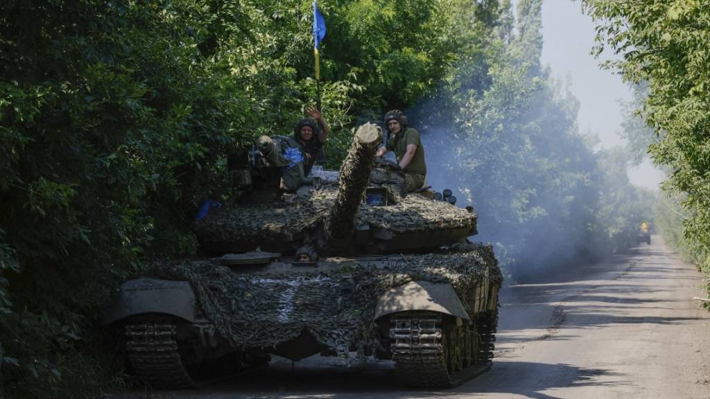 Ukrainische Soldaten fahren auf einem T-64-Panzer an der Frontlinie in der Nähe von Bachmut. Foto: Alex Babenko/AP/dpa