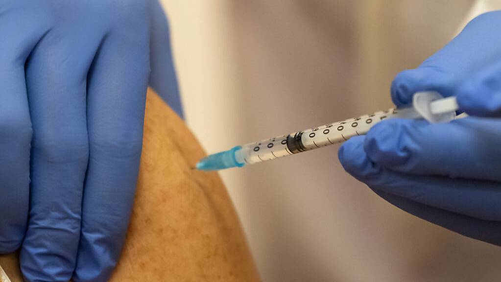 ARCHIV - Ein Mann erhält eine Corona-Impfung. Foto: Michael Reichel/dpa/Symbolbild