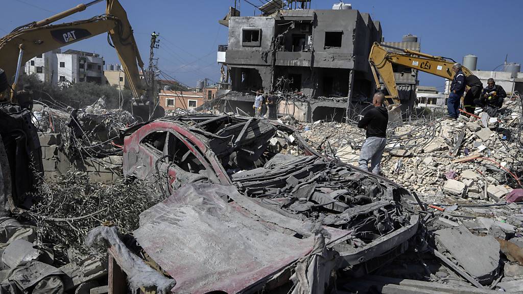 Rettungskräfte entfernen mit Baggern die Trümmer eines zerstörten Gebäudes, das bei einem israelischen Luftangriff getroffen wurde. Foto: Bilal Hussein/AP/dpa