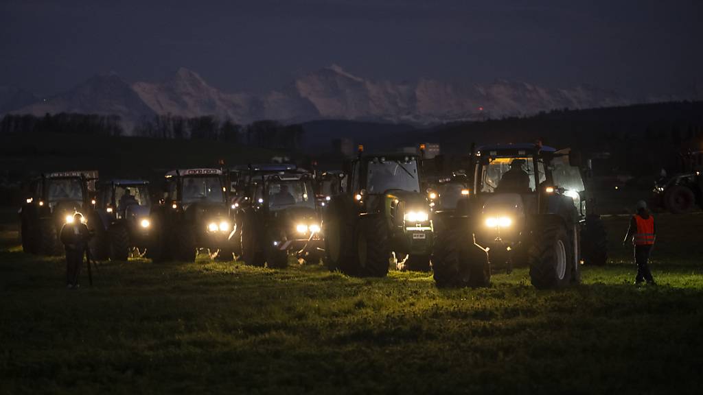 Vertreterinnen und Vertreter der Bauernbewegung fanden sich am Freitagabend mit ihren Traktoren zu einer Mahnwache in Kirchberg BE ein. Im Hintergrund die Berner Alpen mit Eiger, Mönch und Jungfrau.
