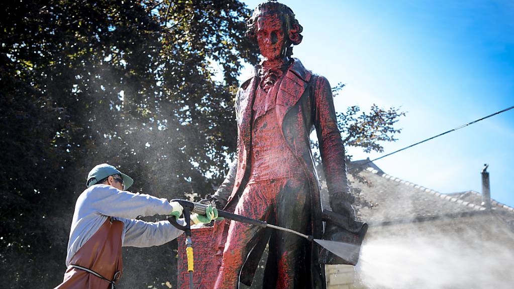 Ein Angestellter reinigte am Montagmorgen die Statue des umstrittenen Händlers David de Pury von der roten Farbe. De Pury lebte im 18. Jahrhundert.