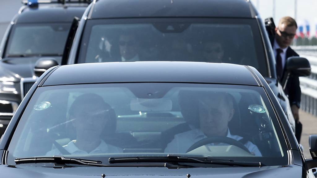 Der russische Präsident Wladimir Putin (r) fährt einen Lada Aura bei der Eröffnungs-Zeremonie. Foto: Vyacheslav Prokofyev/Pool Sputnik Kremlin/AP/dpa
