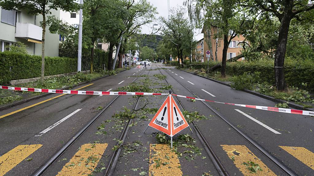 Umgestürzte Bäume und abgebrochene Äste behindern nach einem schweren Unwetter in Zürich am 13. Juli 2021 den Verkehr und das Durchkommen für Fussgänger. Kräftige Gewitter mit Starkregen, Hagelschlag und Sturmböen zogen im 2021 mehrfach über Teile der Schweiz.