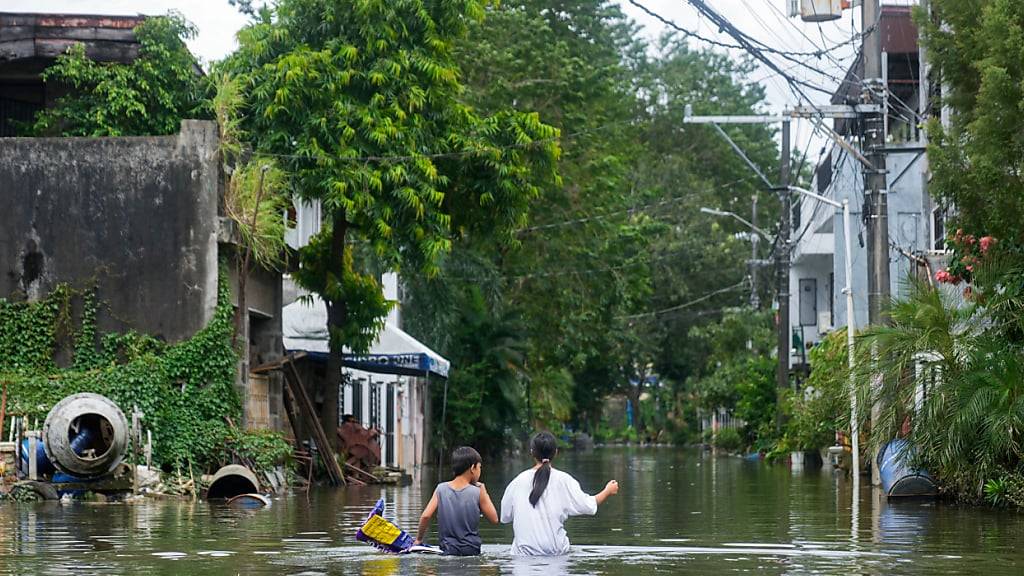 Einwohner gehen in Cainta, Provinz Rizal, Philippinen, durch das vom Tropensturm «Trami» überflutete Dorf. Foto: Aaron Favila/AP