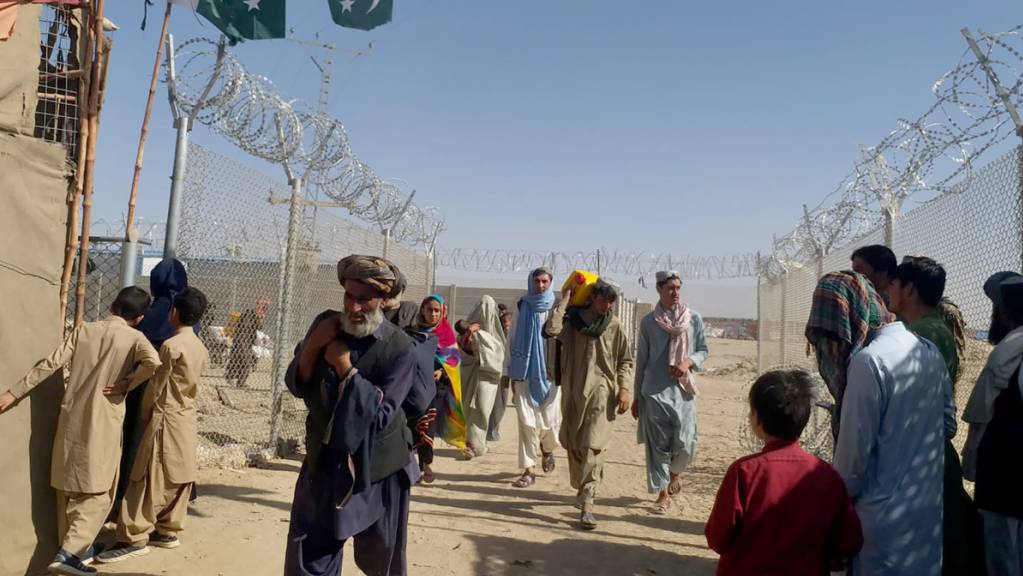 Menschen aus Afghanistan reisen am Grenzübergang Chaman, Pakistan, nach Pakistan ein. Foto: Jafar Khan/AP/dpa