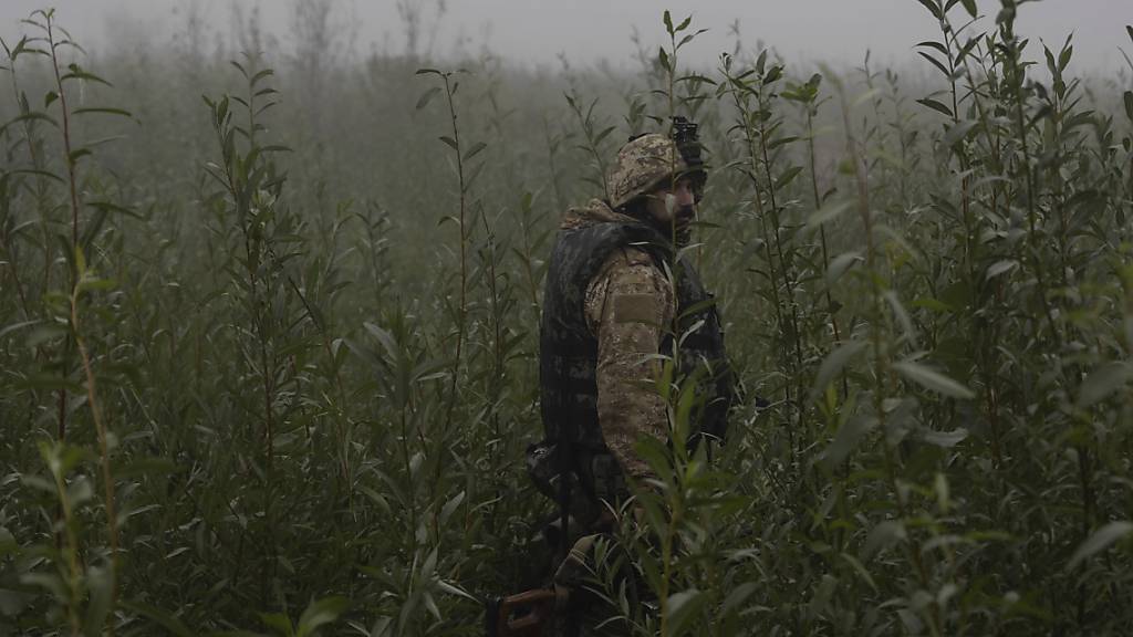 Ein ukrainischer Soldat geht durch ein Gelände an der Frontlinie in Cherson. Foto: Alex Babenko/AP/dpa
