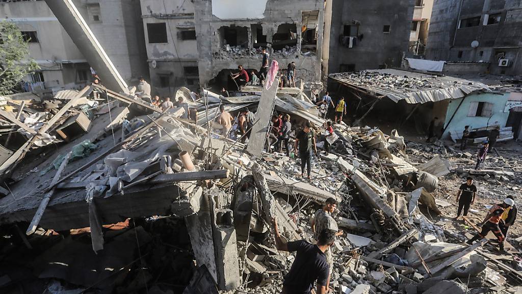 Palästinenser stehen auf den Trümmern eines eingestürzten Gebäudes: Es herrscht eine kritische Versorgungslage. Foto: Mohammed Talatene/dpa