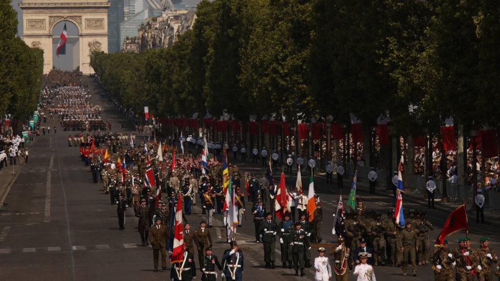 Truppen der sogenannten «Koalition der Willigen» marschieren während der Militärparade zum Bastille-Tag auf den Champs-Elysees. Foto: Thomas Padilla/AP/dpa