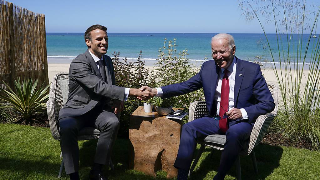 Joe Biden (r), Präsident der USA, und Emmanuel Macron, Präsident von Frankreich, schütteln sich die Hand bei einem gemeinsamen Treffen während des G7-Gipfels. Foto: Patrick Semansky/AP/dpa