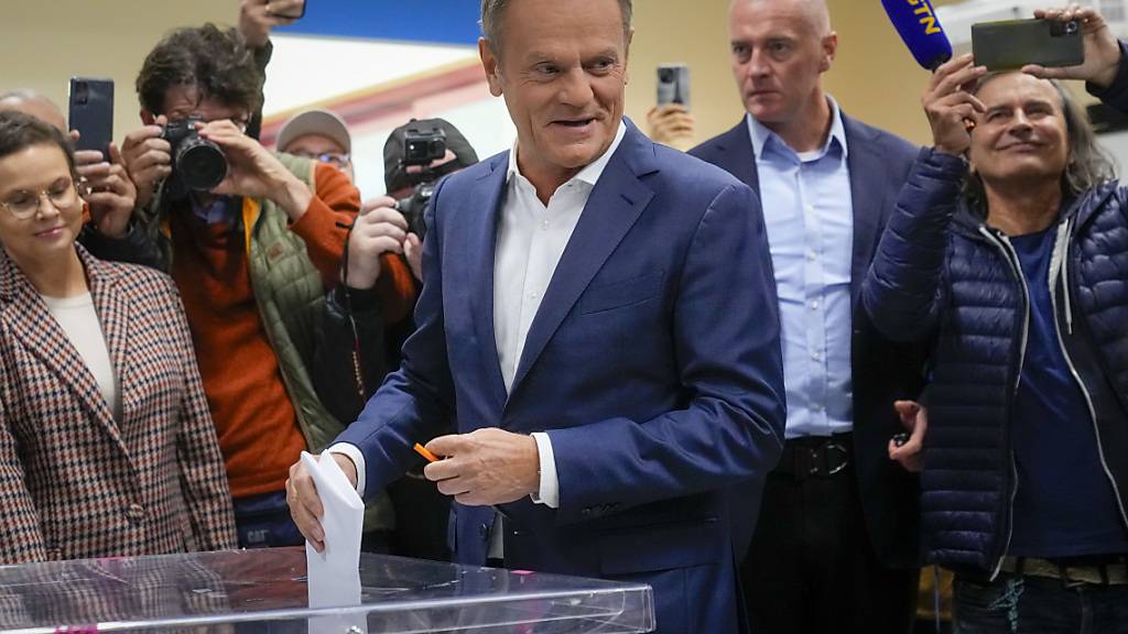 Donald Tusk (M), Oppositionsführer von Polen, bei der Stimmabgabe für die Parlamentswahl. In Polen hat die Parlamentswahl begonnen. Foto: Petr David Josek/AP/dpa
