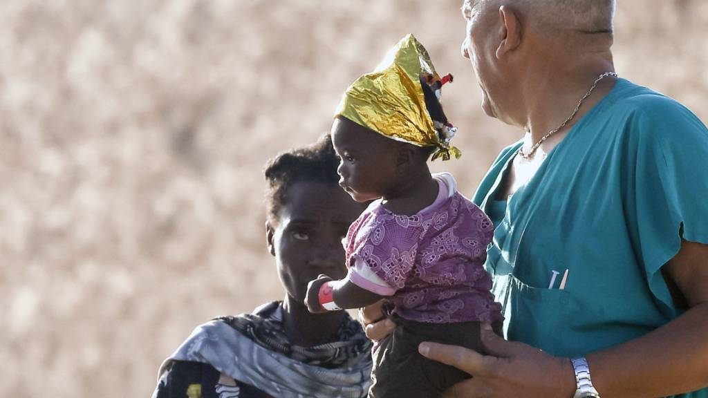 Ein Baby wird von einem Sanitäter getragen, nachdem es im Hafen von Lampedusa von Bord gegangen ist. Foto: Cecilia Fabiano/LaPresse/AP/dpa