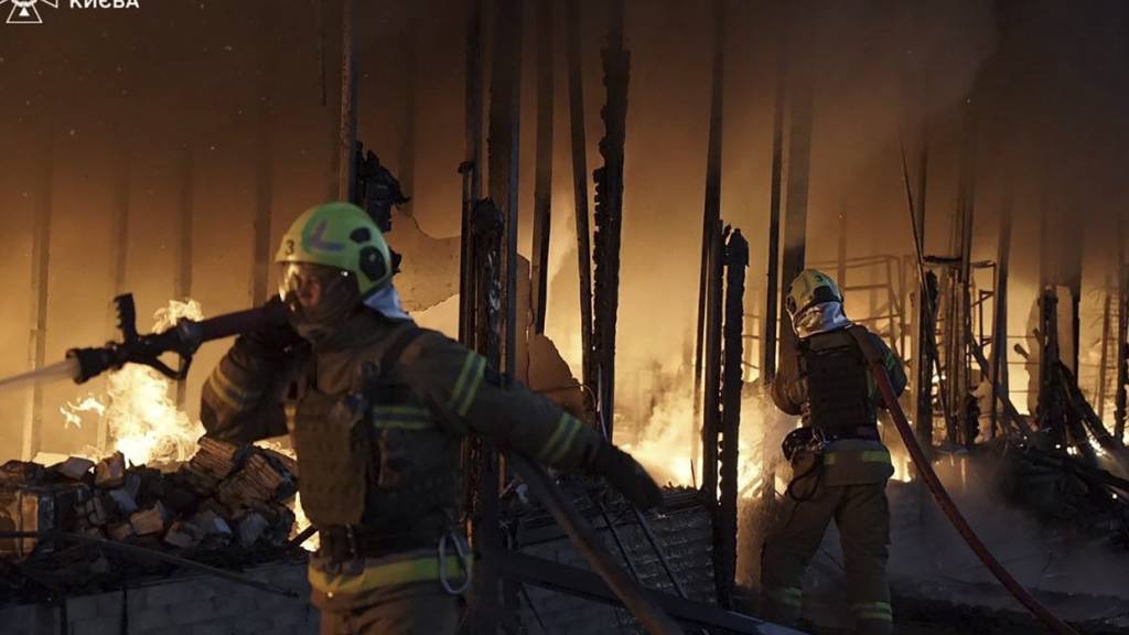 HANDOUT - Rettungskräfte des ukrainischen Rettungsdienstes löschen ein Feuer in einem Gebäude, das durch einen russischen Drohnenangriff entstanden ist. Foto: Uncredited/Ukrainian Emergency Service/AP/dpa - ACHTUNG: Nur zur redaktionellen Verwendung und nur mit vollständiger Nennung des vorstehenden Credits