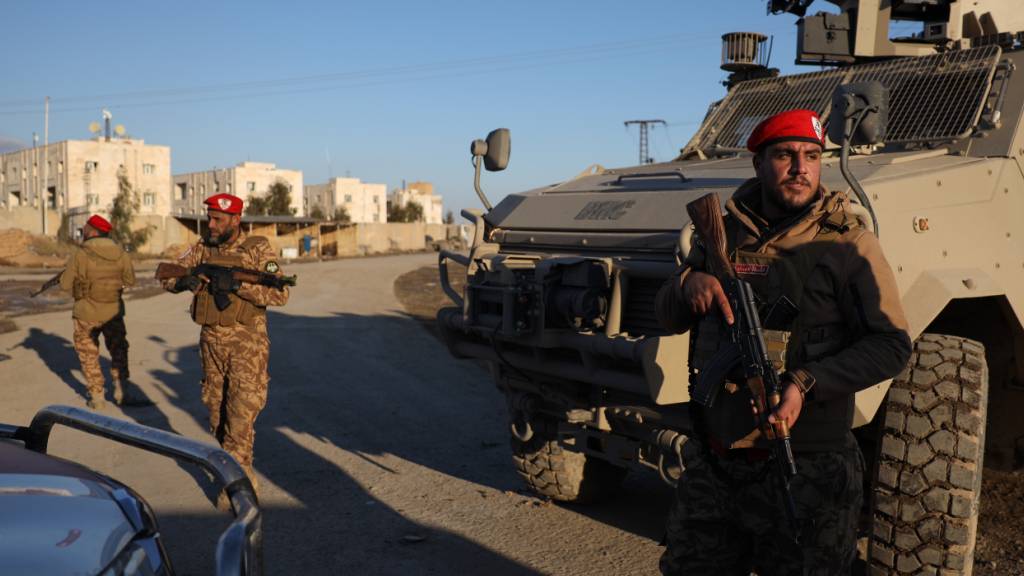ARCHIV - Syrische Regierungstruppen stehen vor dem Al-Aktan-Gefängnis am Stadtrand von al-Rakka im Nordosten Syriens Wache. Foto: Omar Albam/AP/dpa