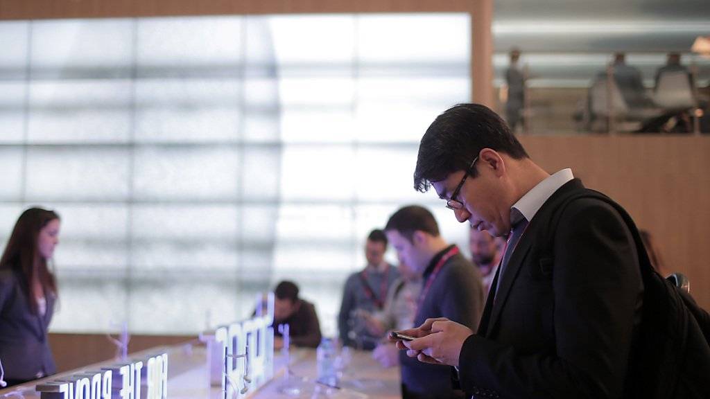 Ein Mann testet ein Huawei-Smartphone während des diesjährigen Mobile World Congress in Barcelona: Der chinesische Telekommunikationsriese will sich auch im Premiumsegment etablieren (Archiv).