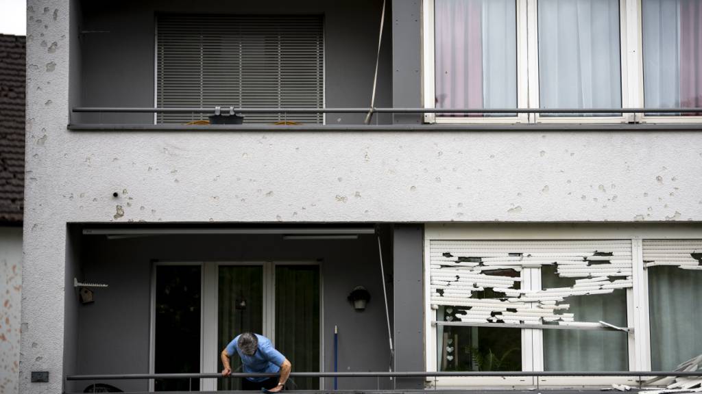 Eine Frau reinigt ihren Balkon nach dem heftigen Hagelgewitter am 28. August in Bülach. (Archivbild)