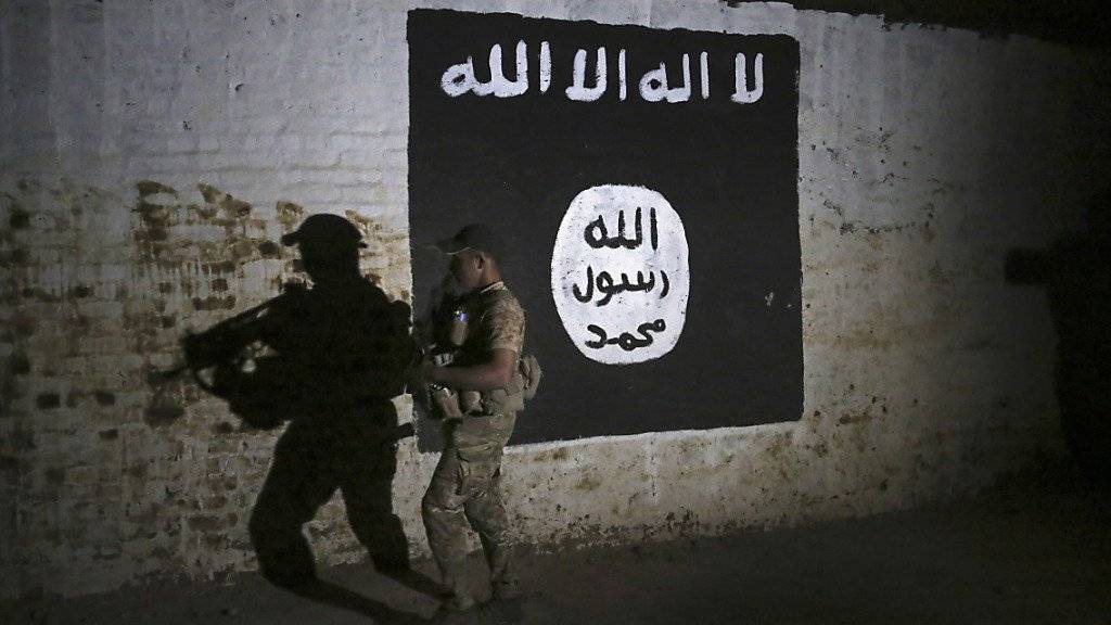 Ein irakischer Soldat inspiziert einen Eisenbahntunnel mit einer aufgemalten Flagge der Terrormiliz Islamischer Staat (IS). (Archivbild)