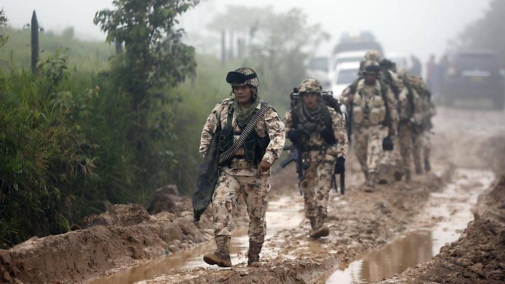 Beschwerlicher Weg zum Frieden: Kolumbianische Soldaten marschieren zu einem FARC-Lager, wo die Rebellen ihre Waffen abgegeben haben.