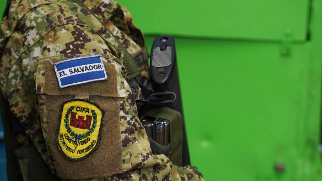 ARCHIV - Ein bewaffneter Soldat steht Wache und trägt an seinem Arm das Motto: «Mit Aufbau und Vernichtung werden wir siegen». Im umstrittenen Kampf gegen die Kriminalität durch den konservativen Präsidenten Bukele spielt das Militär eine bedeutende Rolle in dem mittelamerikanischen Land. Foto: Camilo Freedman/dpa