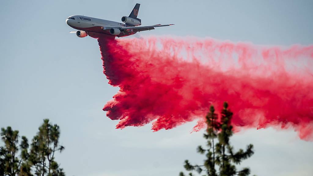 Ein DC-10 Tankflugzeug wirft Löschmittel ab, um die Ausbreitung des Salt Fire in der Nähe von Lakehead im Shasta County zu begrenzen. In Kalifornien verschärfte heißes und trockenes Wetter die Feuerlage. Im Norden brannten drei größere Feuer, die Tausende Menschen zeitweise in die Flucht schlugen. Foto: Noah Berger/AP/dpa