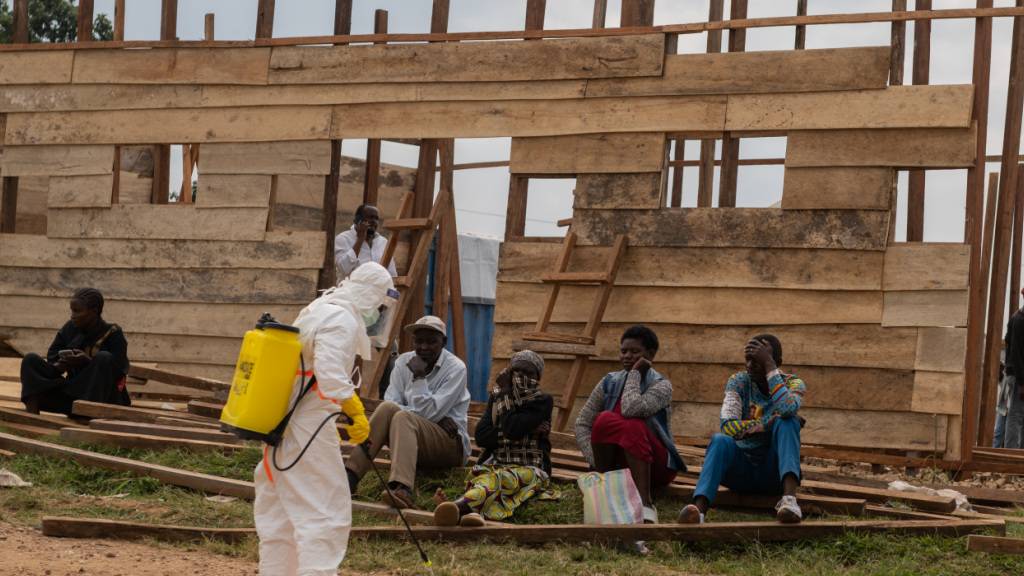 ARCHIV - Ein Mitarbeiter des Gesundheitswesens desinfiziert den Bereich um eine im Bau befindliche Behandlungsstation im Allgemeinen Krankenhaus in Bunia. Foto: Moses Sawasawa/AP/dpa