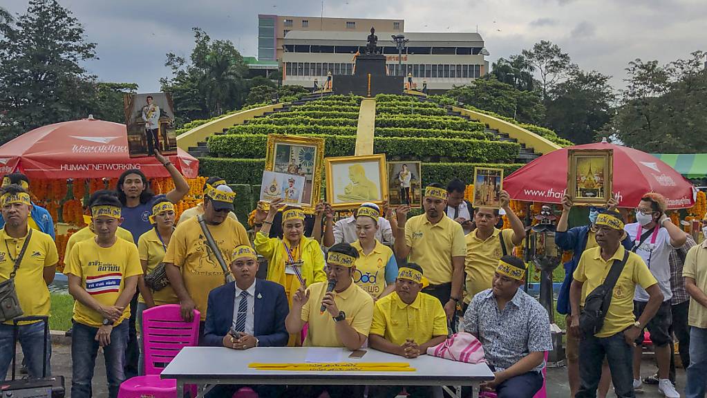 Demonstranten tragen gelbe Kleidung und halten Abbildungen des thailändischen Königs Maha und der Königin Suthida bei einem Protest vor der Ramkhamhaeng Universität, um ihre Loyalität für die Institution unter Beweis zu stellen. Foto: Peerayot Lakkananukul/AP/dpa